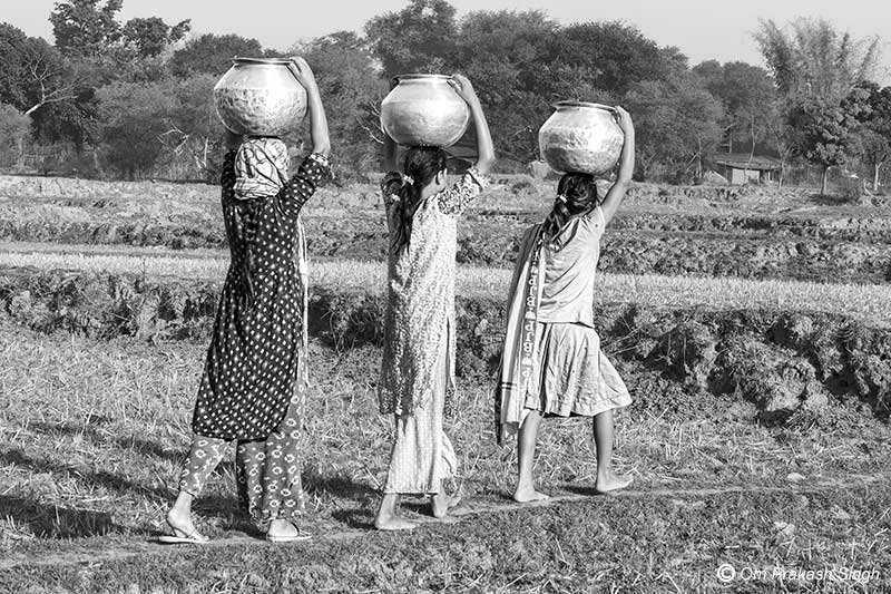 Girls hauling drinking water from a distant traditional source in Khunti district, Jharkhand, India